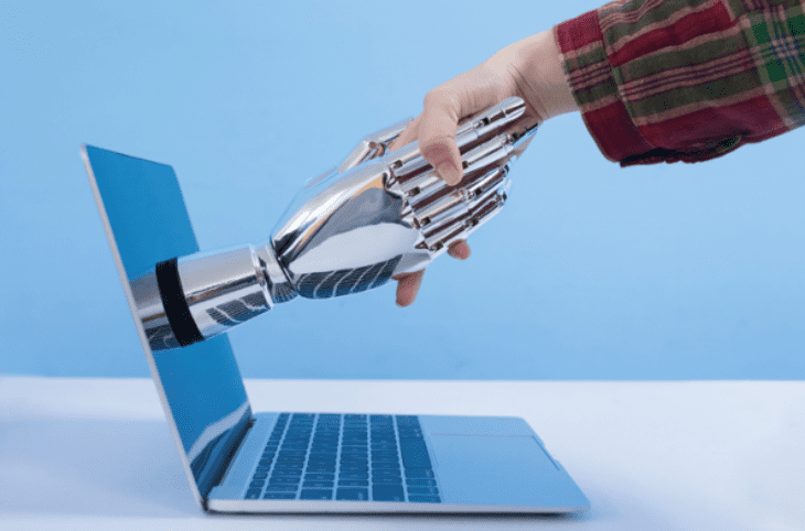 Laptop_on_table_Robot_Hand_coming_out_of_screen_shaking_human_hand